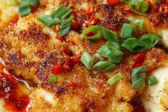 Cajun Chicken served with cheesy grits in a vibrant dish