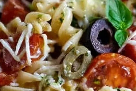 Bowl of colorful Italian pasta salad with fresh vegetables and dressing