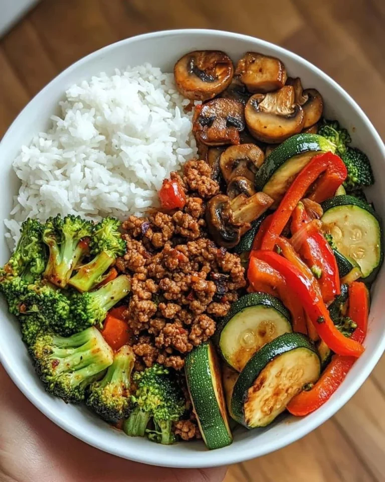 Spicy beef stir-fry bowl with garlic vegetables and steamed rice